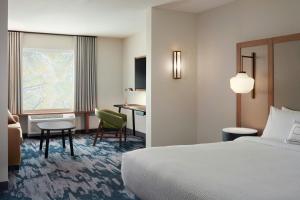 a hotel room with a bed and a desk at Fairfield by Marriott Inn & Suites Morrow in Morrow