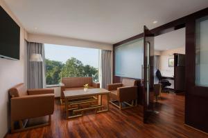 a room with a table and chairs and a large window at The Fern Residency Jodhpur, Series by Marriott in Jodhpur
