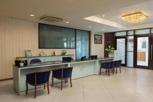 a lobby with a reception desk with blue chairs at The Fern Residency Jodhpur, Series by Marriott in Jodhpur +9 photos