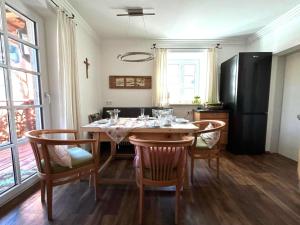 a kitchen with a table with chairs and a refrigerator at Naturpark Chalet Schladming-Dachstein in Großsölk +22 photos