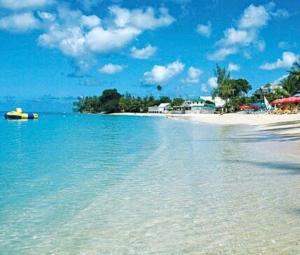 a view of a beach with blue water and buildings at Mullins Bayfield Gardens House in Saint Peter