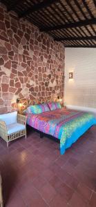 a bed in a room with a stone wall at Sandy Shores Cabaña 10A in La Paz