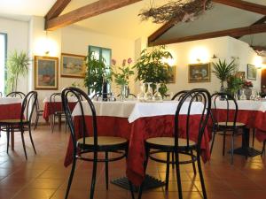 un ristorante con tavolo, sedie e fiori di Hotel Rurale Canneviè a Lido di Volano