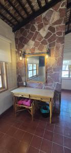 a bench in a room with a mirror on a stone wall at Sandy Shores Cabaña 10A in La Paz