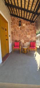 two red chairs and a table on a patio at Sandy Shores Cabaña 10A in La Paz +19 photos