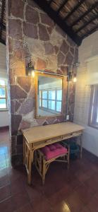 a wooden bench with a mirror on a stone wall at Sandy Shores Cabaña 10B in La Paz