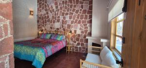 a bedroom with a bed and a stone wall at Sandy Shores Cabaña 10B in La Paz