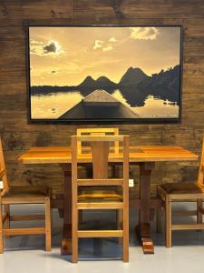 a wooden table with chairs and a painting on a wall at Kaza Living Usaquén in Bogotá