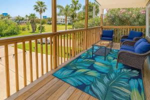 a balcony with two chairs and a table and a rug at Bay View Great Deck Pool 2 levels & 3 bedr condo in South Padre Island
