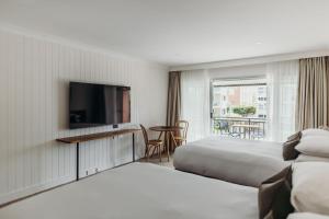 a hotel room with two beds and a flat screen tv at Hotel Nelson in Nelson Bay +59 photos