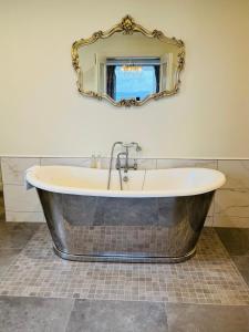 a bath tub in a bathroom with a mirror at The Blue Haven Kilcar in Donegal +44 photos