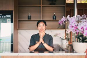 a woman is sitting at a counter with her hands in front at STHANATAPA HILL's in Sidemen
