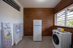 a kitchen with a refrigerator and a washing machine at Rio - Destination Guyane in Macouria