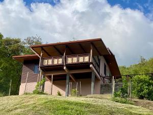 a house on top of a grassy hill at ManaHenua Lodge in Nuku Hiva