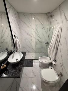 a white bathroom with a toilet and a sink at Apart Hotel CABA in Buenos Aires +16 photos