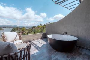 a bath tub on a patio with a view of the water at Roka Hotel in Guatapé