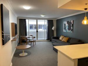 a living room with a couch and a table at Hotel styling entire one bedroom in Sydney