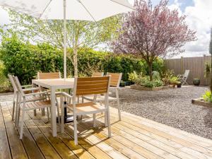 a table and chairs with an umbrella in a garden at Marigold in Shepton Mallet