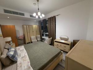 a bedroom with a bed and a dresser and a room at A luxurious room with a breathtaking view in Sharjah