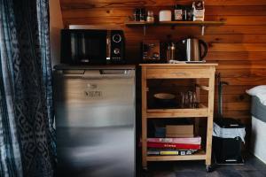 a kitchen with a stainless steel refrigerator and a microwave at The Dome Waikino in Waikino +16 photos
