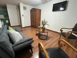 a living room with a couch and a table at Acogedor y céntrico Departamento in León