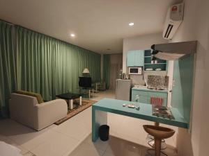 a kitchen and living room with a green curtain at Santorini Hotel in Miri