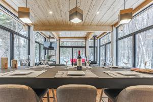 ein Esszimmer mit einem großen Tisch mit Stühlen und Fenstern in der Unterkunft Chic & Bois in La Conception