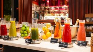 a table with many different colored drinks in vases at Hotel Indigo Brussels - City by IHG in Brussels
