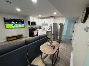 a living room with a couch and a kitchen with a tv at Alake Villa in Saskatoon