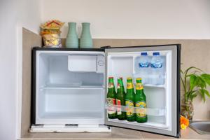 an open refrigerator filled with bottles of soda at Asaka Private Villa in Nusa Penida