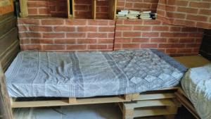 a bed on a wooden platform in a brick wall at Mantiqueira lar doce lar in Gonçalves