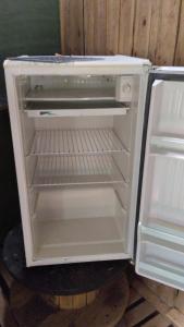 an empty refrigerator with its door open in a kitchen at Mantiqueira lar doce lar in Gonçalves