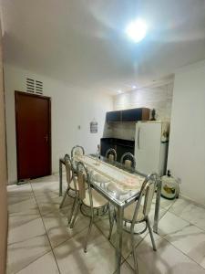 a kitchen with a table and chairs and a refrigerator at Serraruna House no centro histórico in Araruna