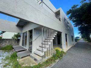 a building with stairs on the side of it at 無料レンタカー付 Value Residence Hotel 腰原 in Miyako-jima