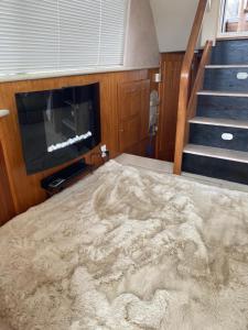 a room with a carpeted floor with a television and stairs at Vilamoura -Boat in Quarteira