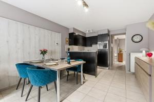 a kitchen and dining room with a table and blue chairs at Walter Vilain 0301 G in Sint-Idesbald +10 photos