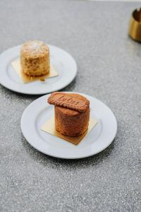 two white plates with cakes on a table at Stay Kertapati Hotel in Kertapati +33 photos