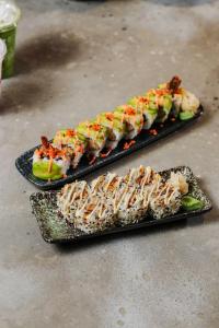 two plates of food with sushi and vegetables on them at Stay Kertapati Hotel in Kertapati