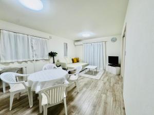 a living room with a table and chairs and a couch at Villa 勝浦 in Katsuura