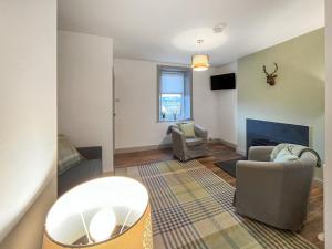 a living room with two chairs and a fireplace at Rubylea in Dumfries