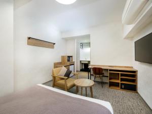 a bedroom with a bed and a desk and a tv at HOTEL MYSTAYS Kiyosumi Shirakawa in Tokyo