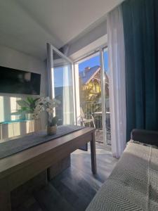 a living room with a table and a large window at Angel in Kołobrzeg