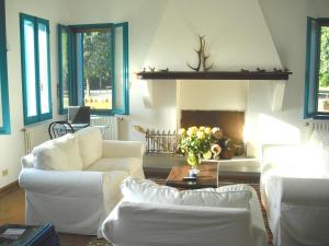 a living room with white furniture and a fireplace at Hotel Rurale Canneviè in Lido di Volano