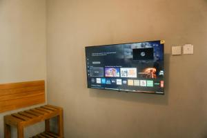 a flat screen tv hanging on a wall at The Umbu Stay Banyuwangi in Banyuwangi