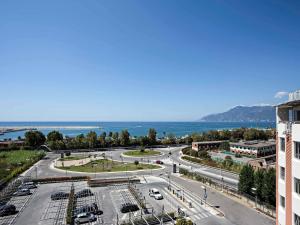 a view of a city with a road and the ocean at Novotel Salerno Est Arechi in Salerno