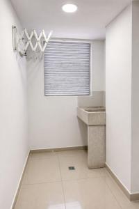 a bathroom with white walls and a sink and a window at Hotel Ivanna - Laureles in Medellín +99 photos