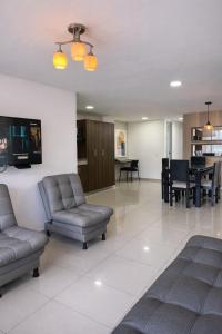 a living room with couches and a dining room at Hotel Ivanna - Laureles in Medellín