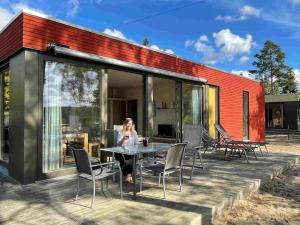 a woman standing on the deck of a house at Bernsteinsee Homes and Ferien Beach House 2 in Sassenburg +28 photos