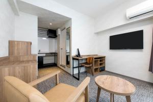 a living room with a couch and a tv on a wall at HOTEL MYSTAYS Kiyosumi Shirakawa in Tokyo +38 photos