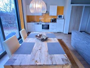 a kitchen with a wooden table with chairs and a dining room at Bernsteinsee Homes and Ferien Beach House in Sassenburg